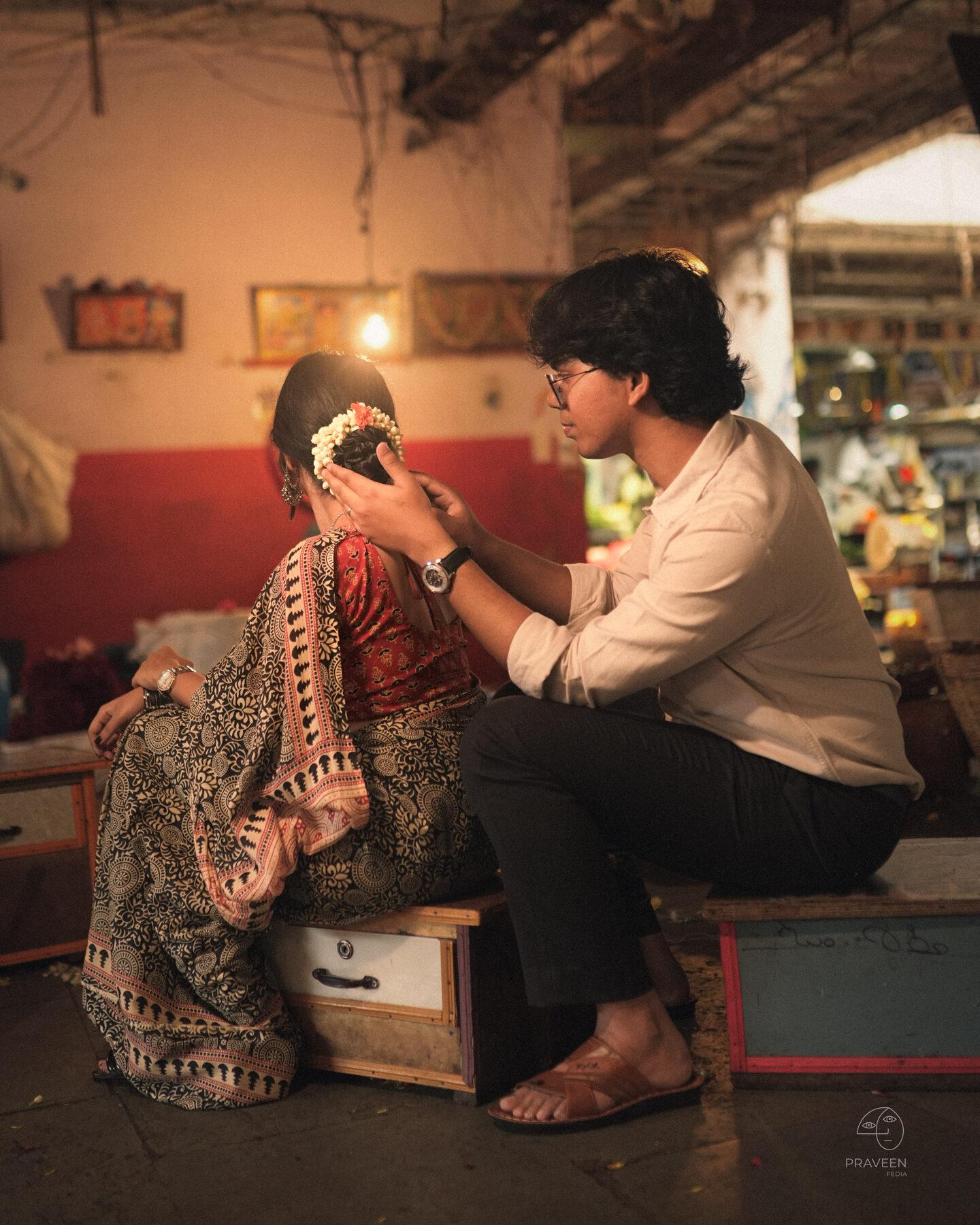 Sudesh pinning jasmine into Pratushya's hair in the old flower market